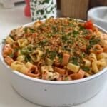 A bowl of heart-shaped pasta topped with shrimp and toasted breadcrumbs.