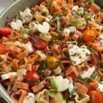 Caprese pasta salad in a bowl using heart-shaped pasta and mozzarella.