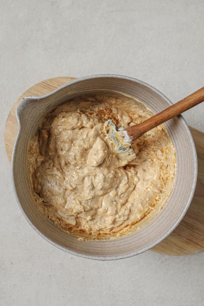 Mixing together ingredients for chicken dip in a large mixing bowl.