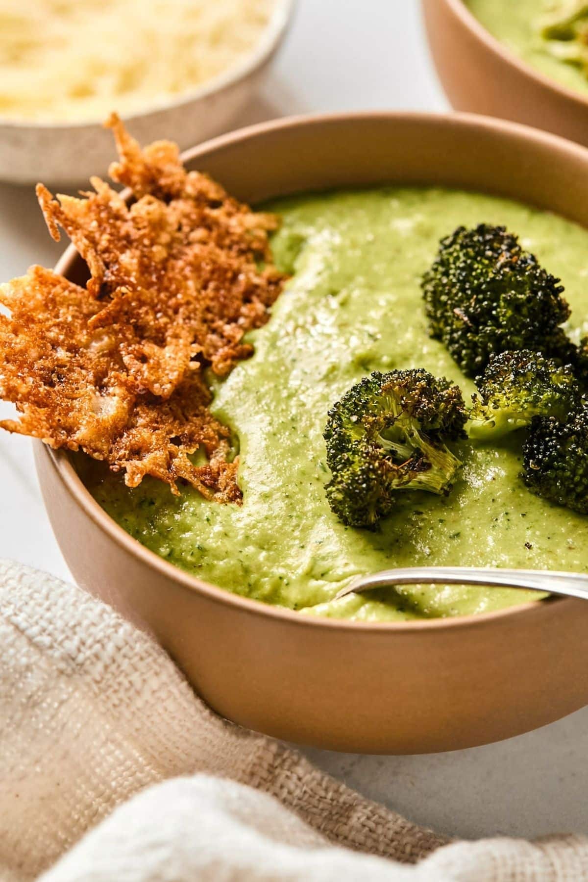 A bowl of broccoli feta soup with Parmesan crisps.