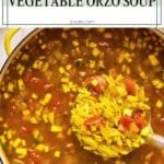 A big pot of vegetable orzo soup with diced zucchini, tomatoes, and orzo pasta with a ladle scooping out a serving.