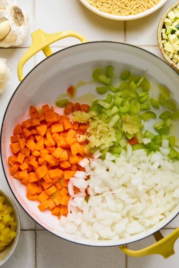 Vegetables sauteeing in a soup pot.