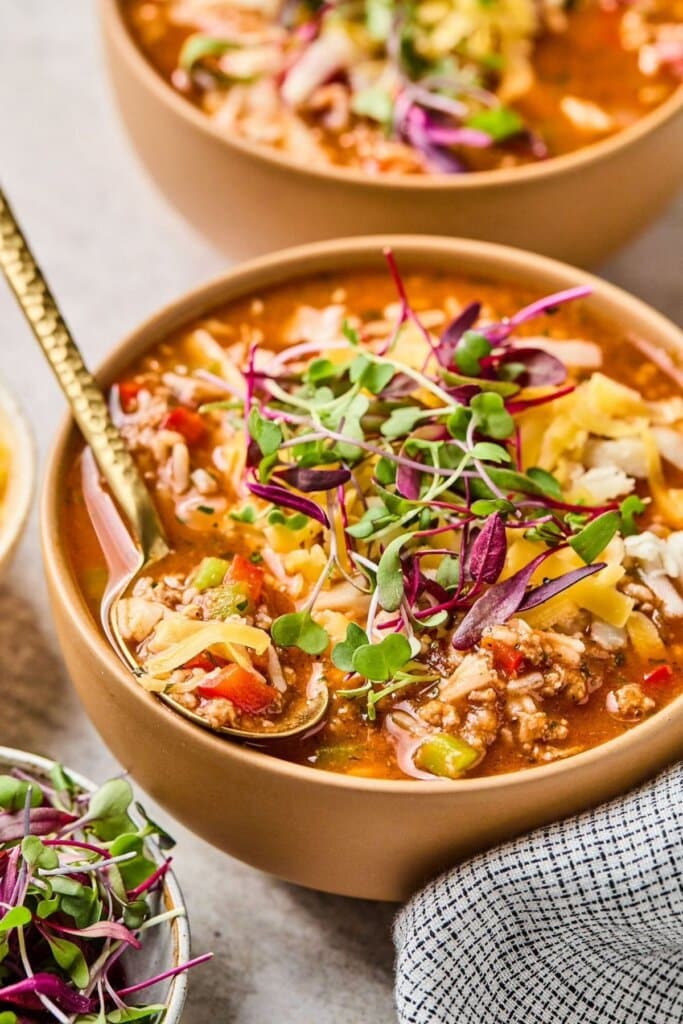 Stuffed pepper soup in a bowl with a gold spoon.