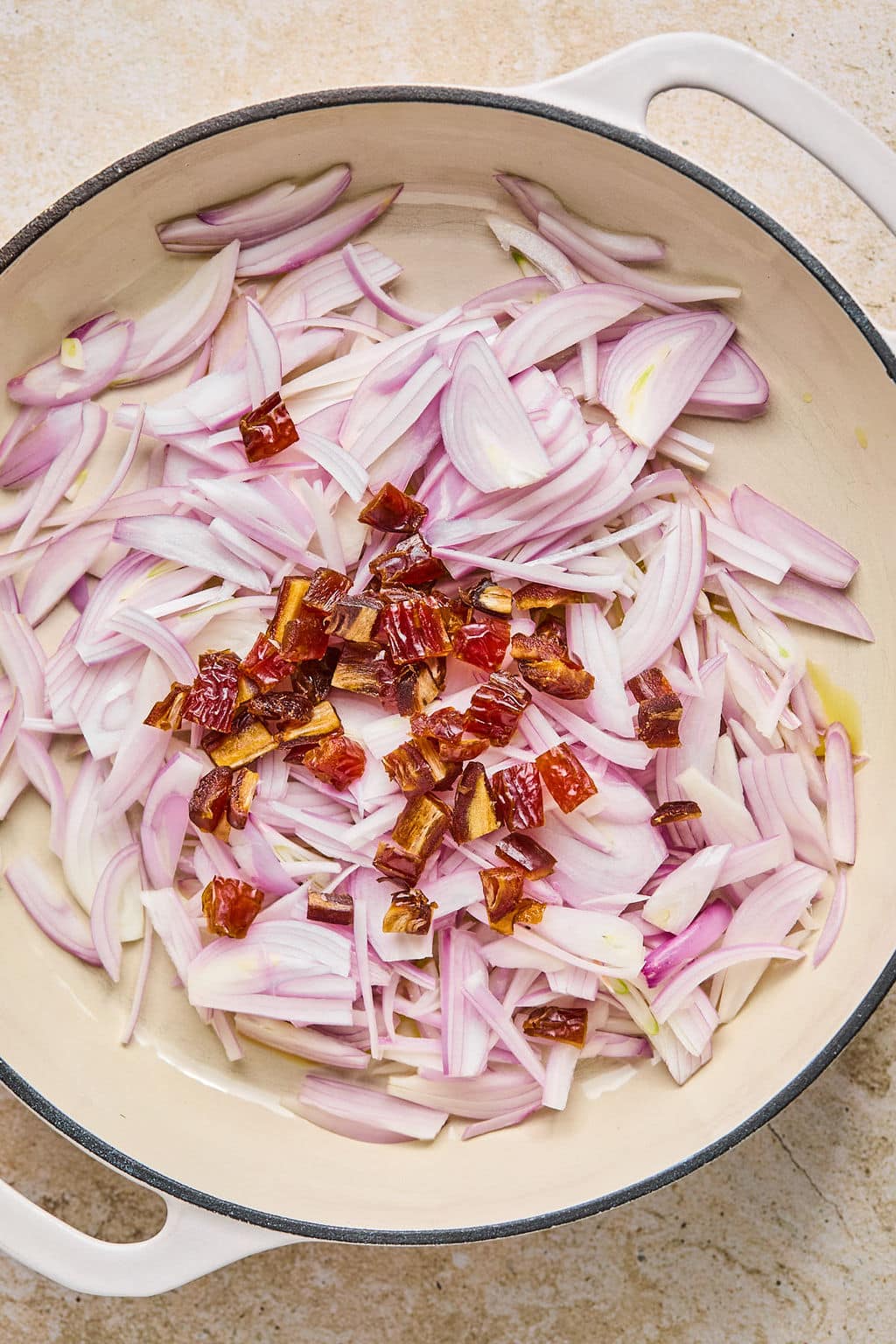 Cooking shallots and dates in a pot.