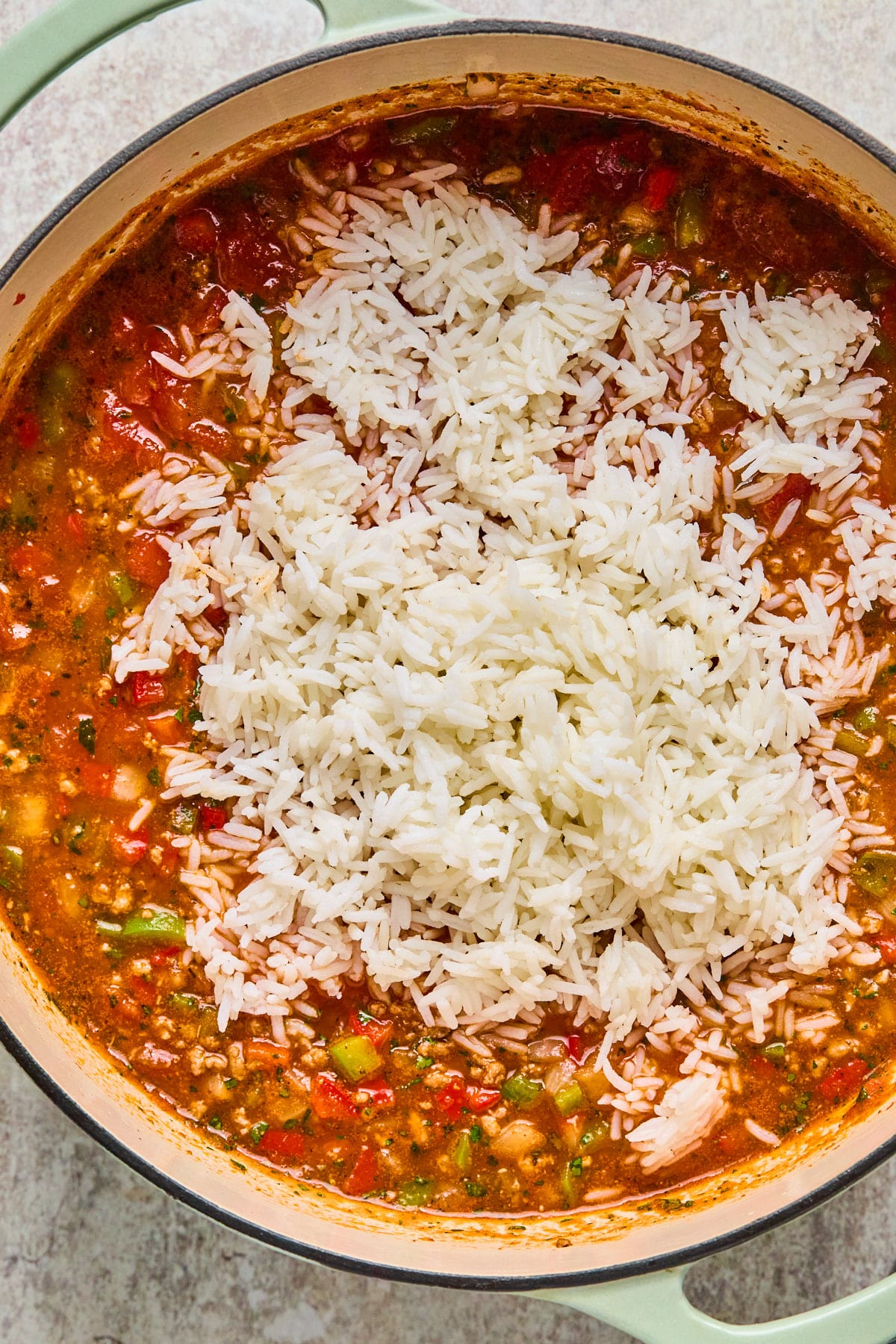 Cooked rice atop stuffed pepper soup base in a pot.