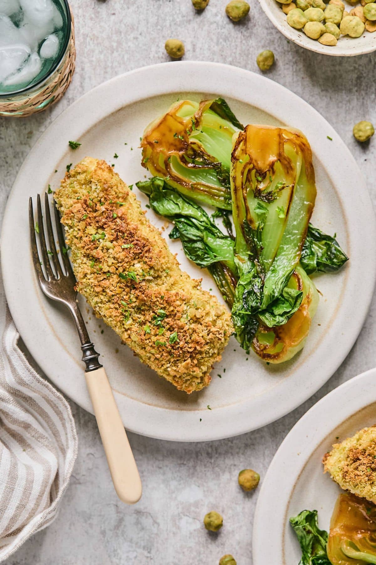 A plate with air fried halibut and bok choy surrounded by ingredients.