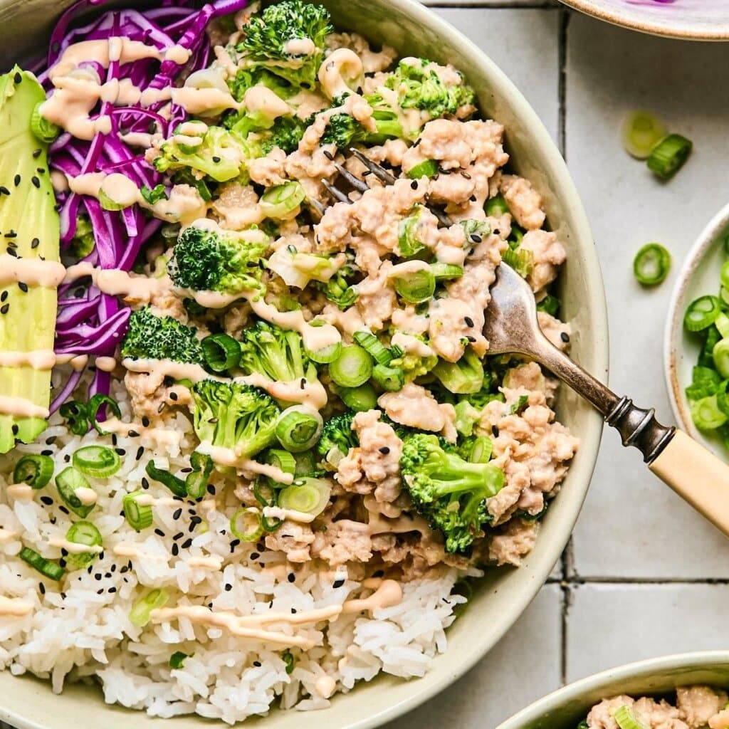 Bang Bang Chicken Rice Bowl on a tile background with a fork in the bowl.