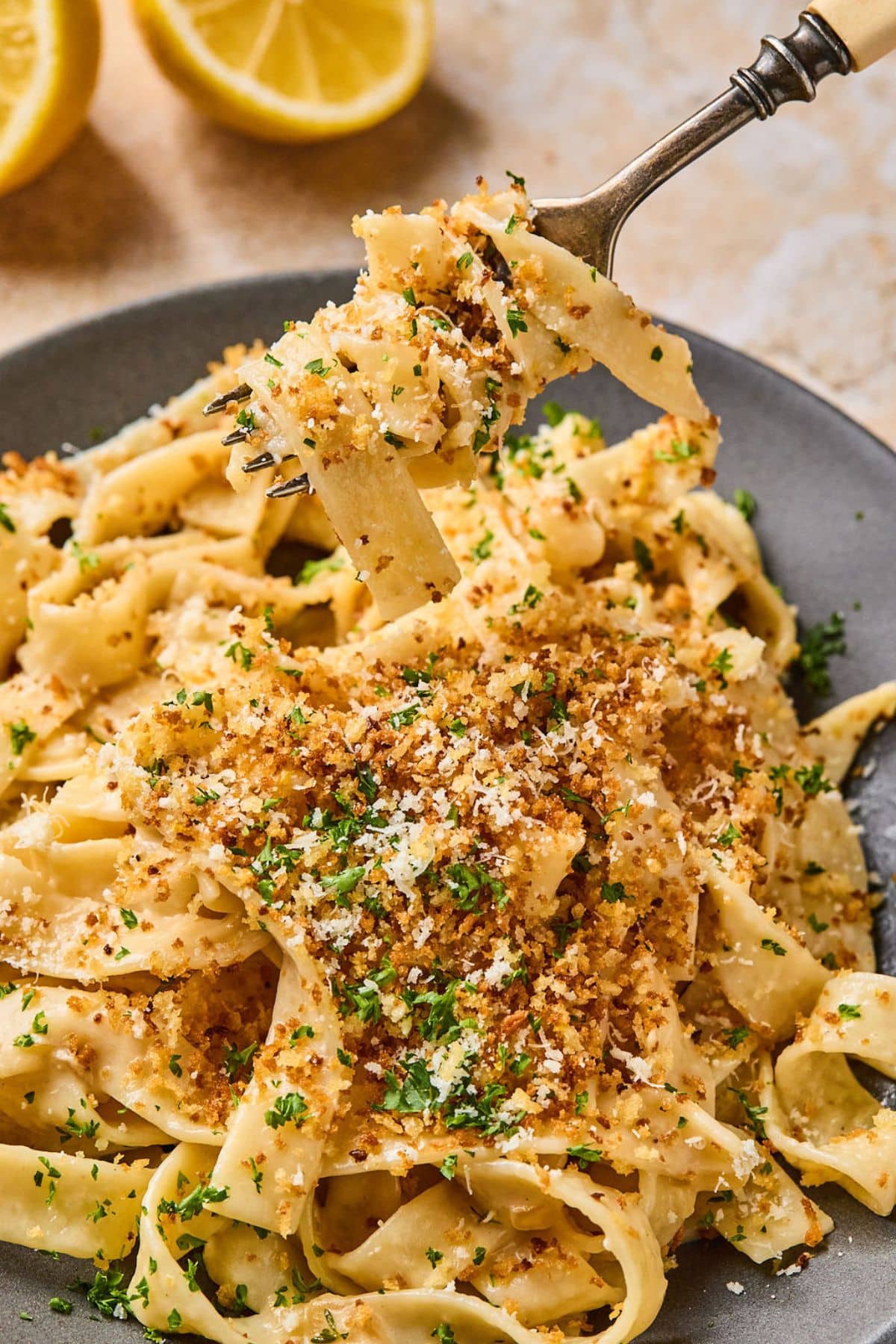 A plate of French onion pasta with a twirled pasta on a fork held above it.