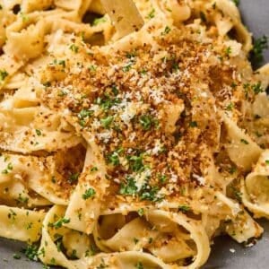 French onion pasta on a plate with toasted panko on top.