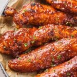 Close up of baked BBQ chicken tenders garnished with parsley.
