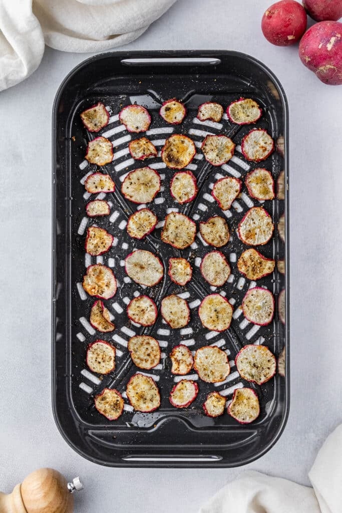 Air fried radishes in a black air fryer basket.