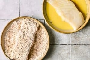Coating halibut filets in egg and bread crumbs.