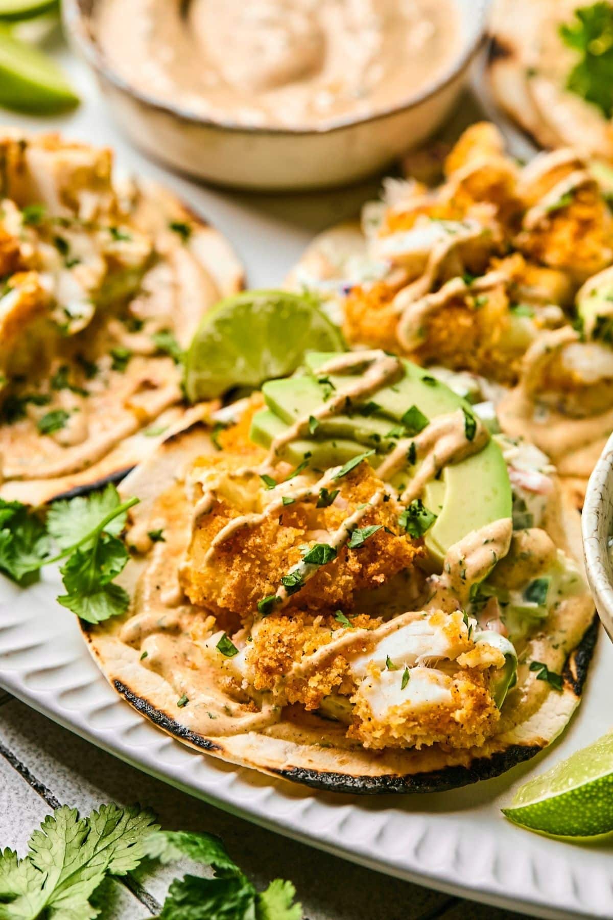 An air fryer fish taco with avocado and a drizzle sauce.
