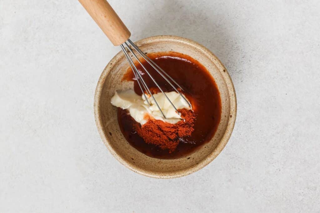 Mixing ingredients for bang bang sauce in a small bowl.