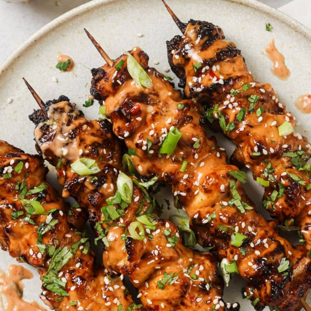 Close up of bang bang chicken skewers on a plate.