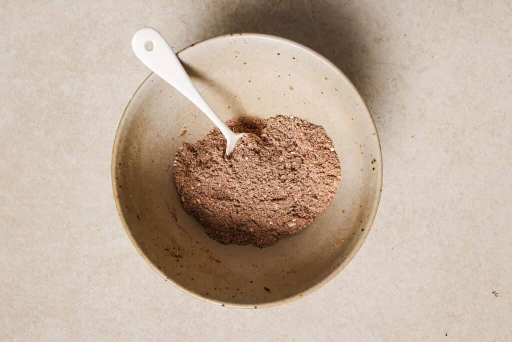 Mixing Cajun spices in a medium schools.