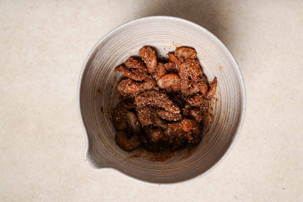 Tossing shrimp in blackened spice.