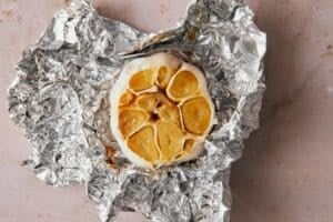 Roasted garlic wrapped in aluminum foil.