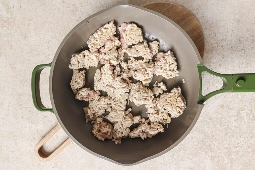 Cooking ground chicken in a skillet.