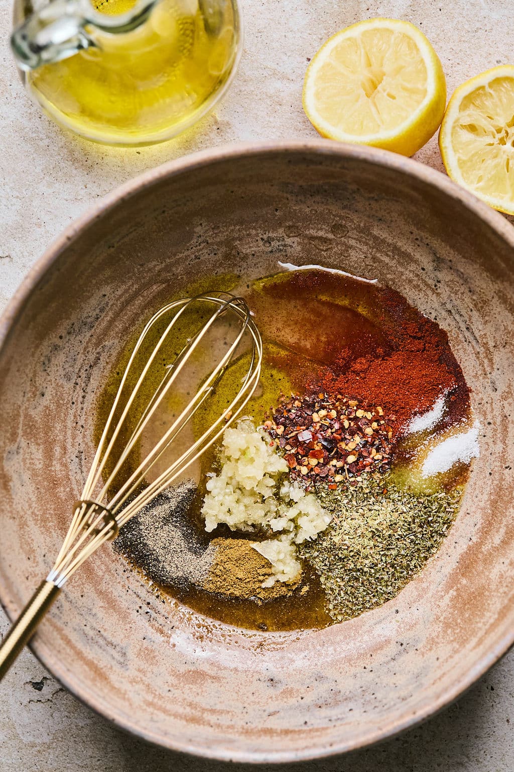 Combining marinade ingredients in a bowl with a whisk.