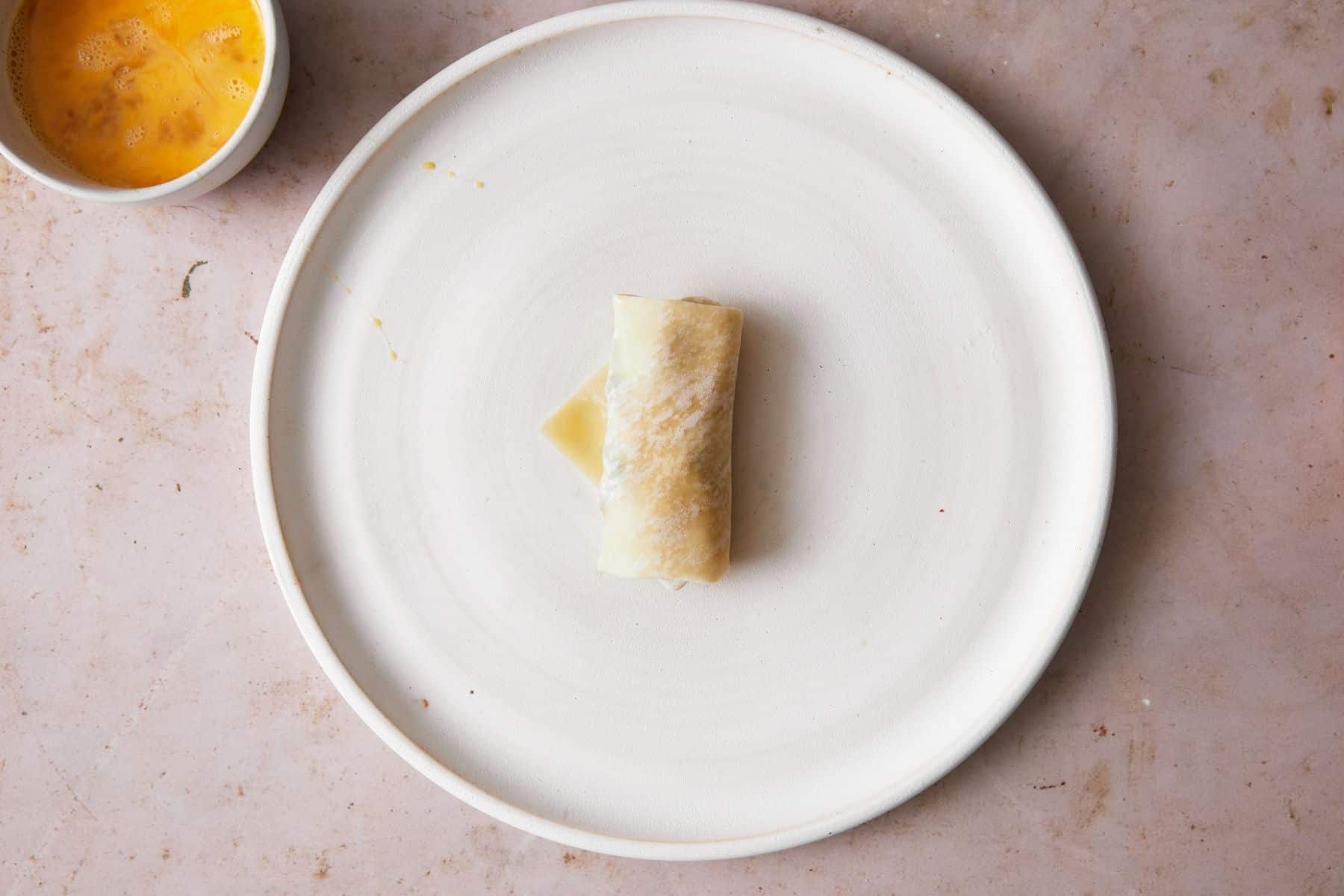 Fully rolling up a philly cheesesteak egg roll.