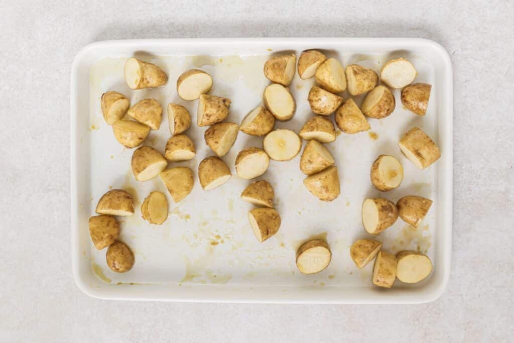 Halved potatoes on a baking sheet.