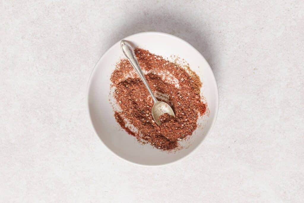 Combining spices in a small bowl.
