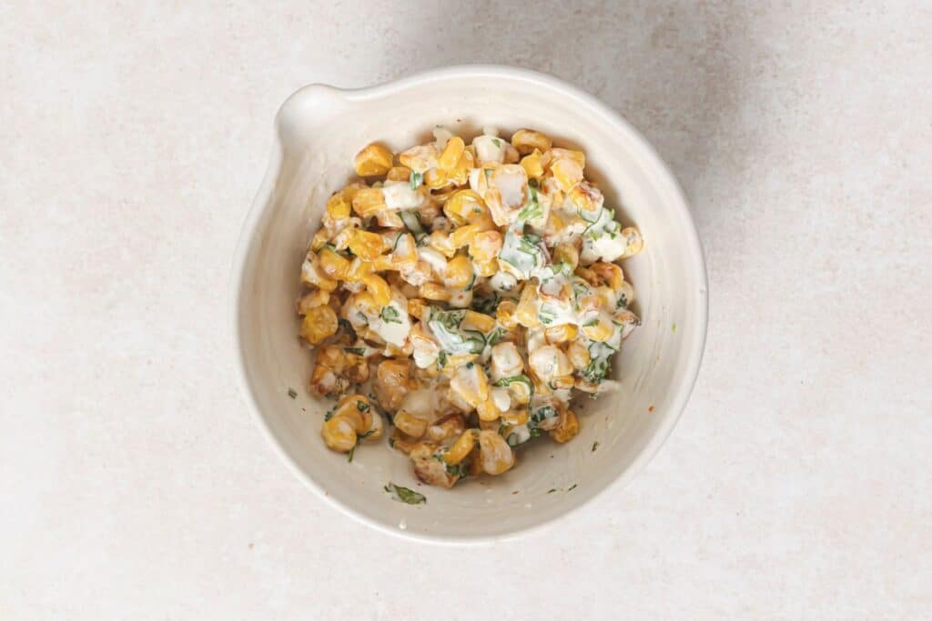 Combining fire roasted corn with homemade sauce.