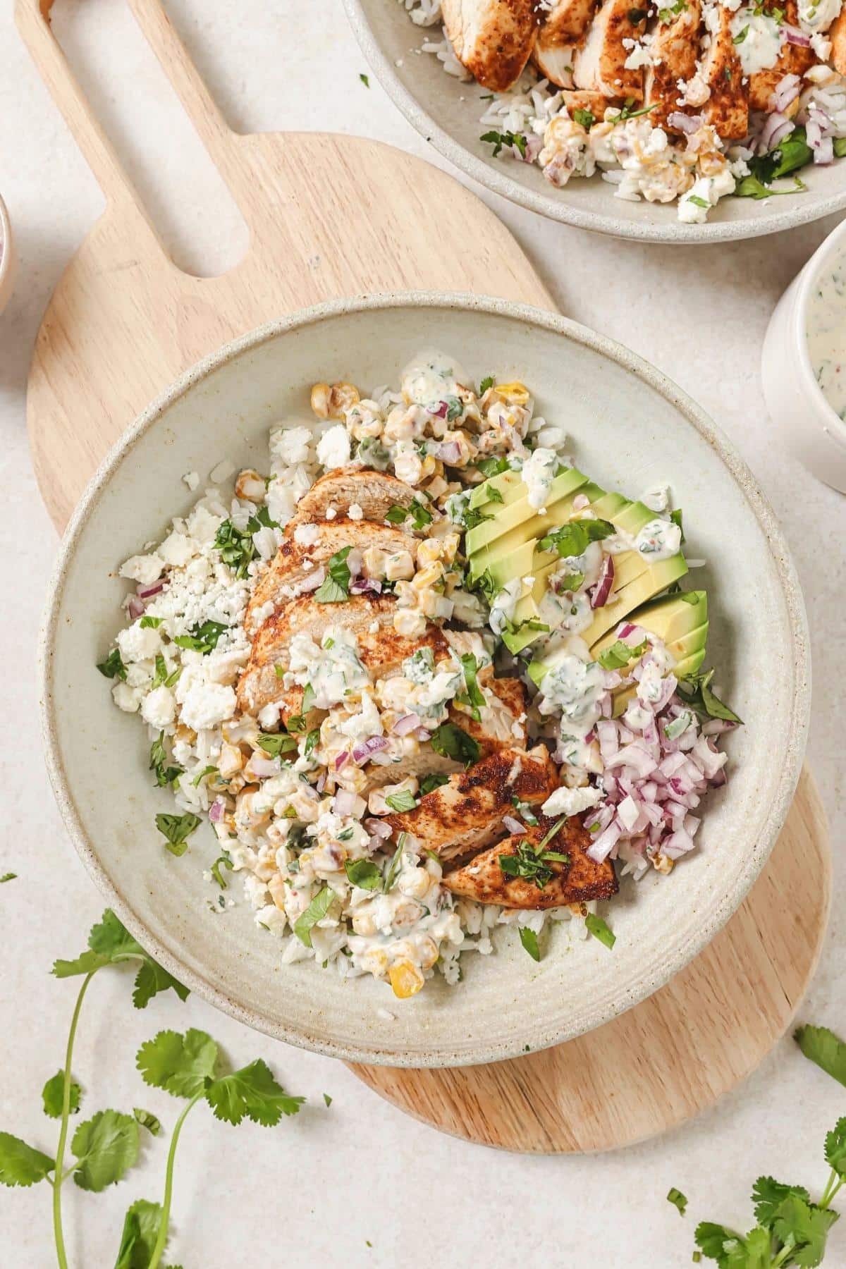 A street corn chicken rice bowl on a cutting board.