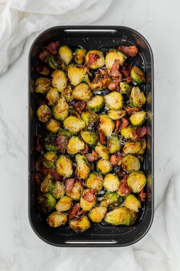 cooked brussels sprouts and bacon in an air fryer basket