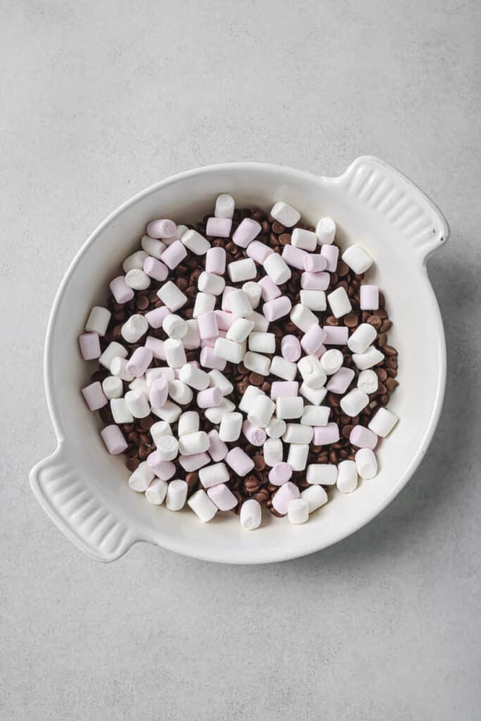 mini marshmallows and chocolate are in a white baking dish