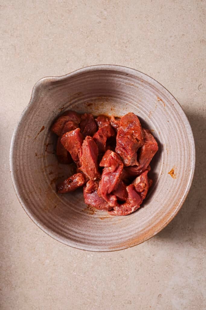 A bowl of marinating steak.
