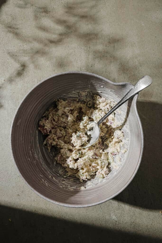 Making jalapeno popper filling in a gray mixing bowl.