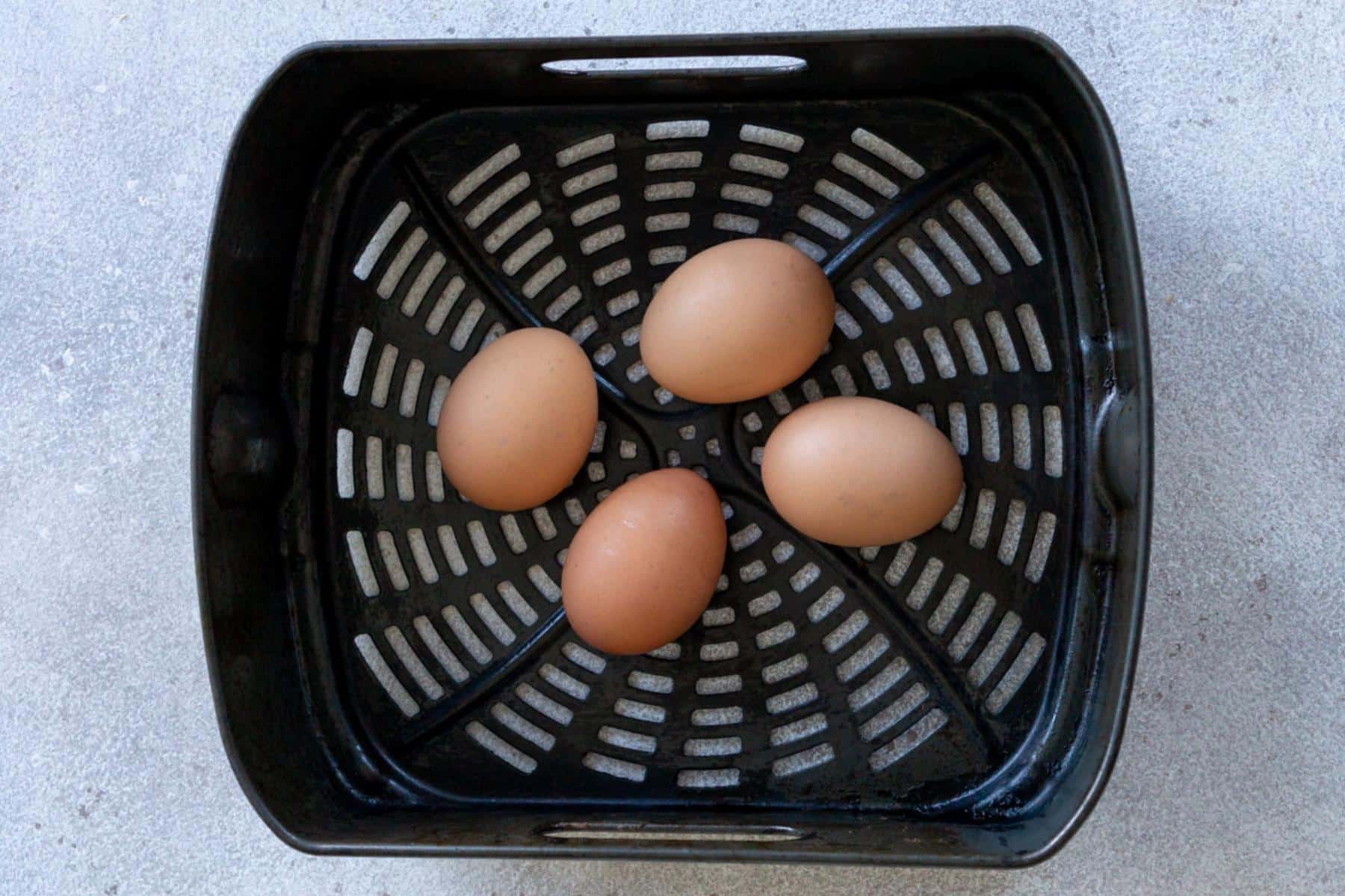 Eggs in an air fryer basket.