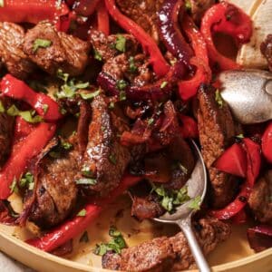 Using a spoon to scoop up air fryer fajitas.