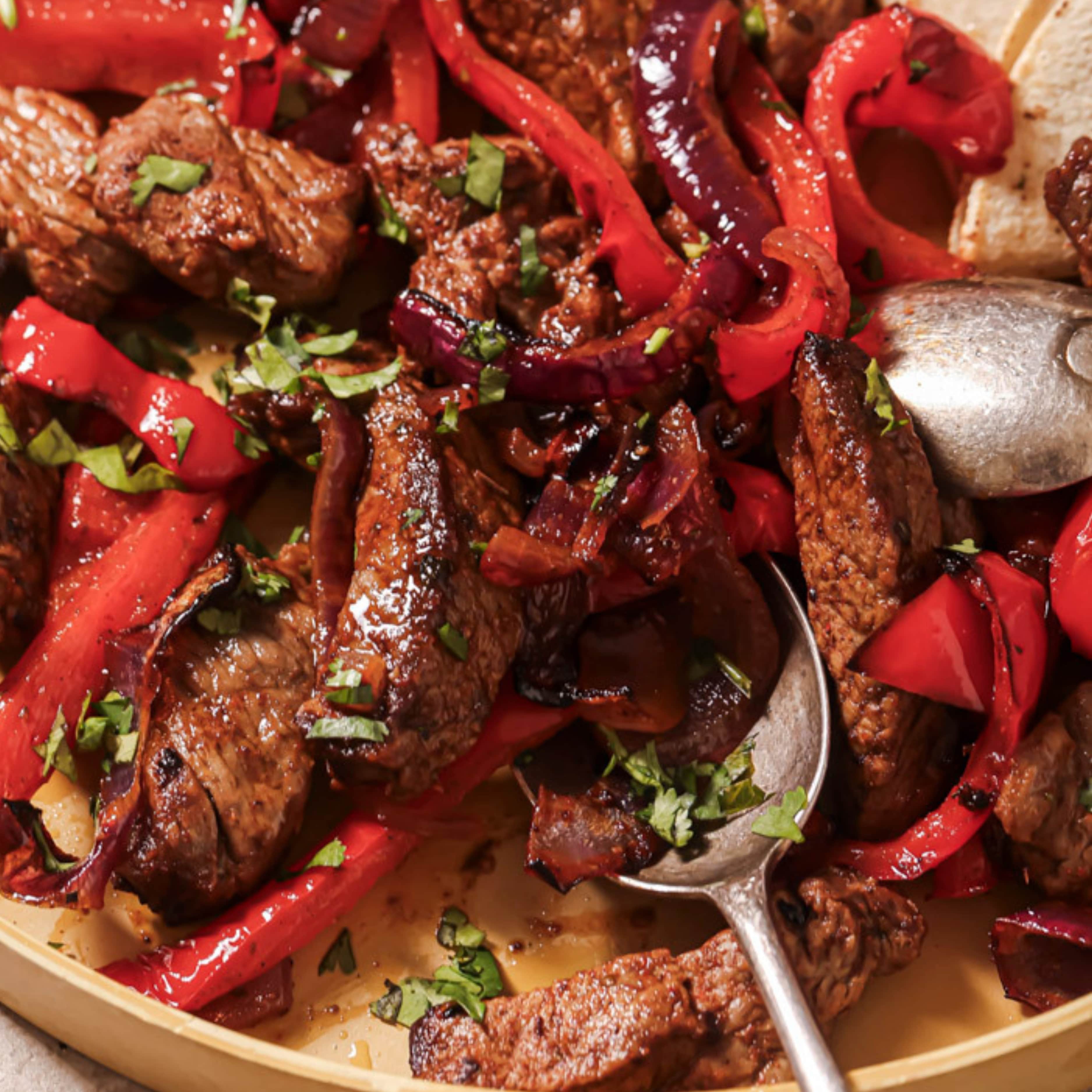Using a spoon to scoop up air fryer fajitas.