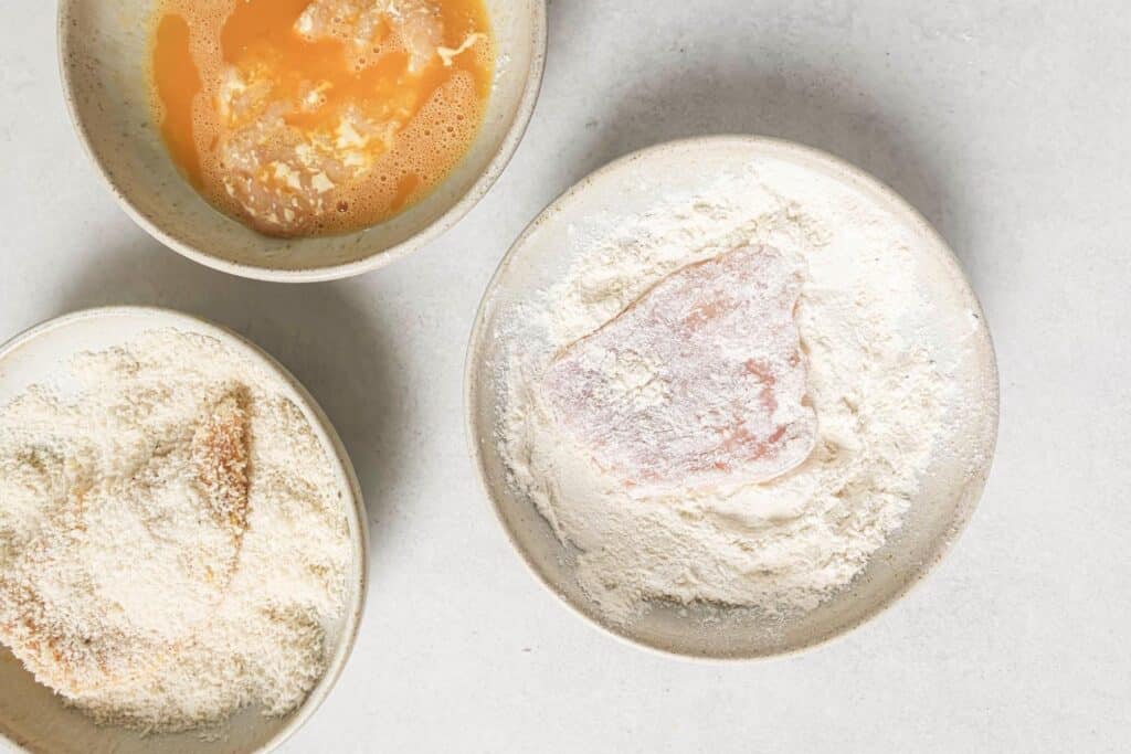 Coating chicken cutlets in flour, eggs, and Panko