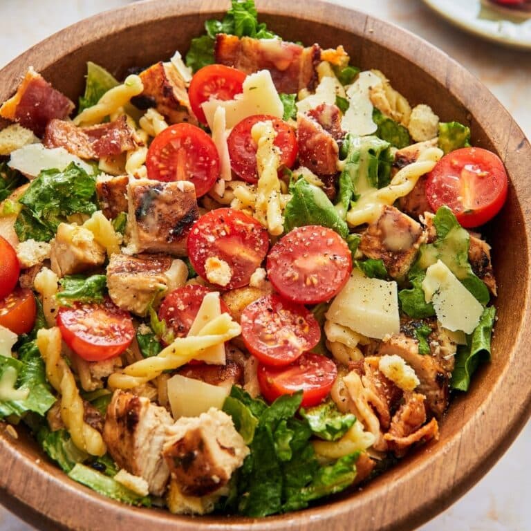 Caesar pasta salad in a wooden bowl.