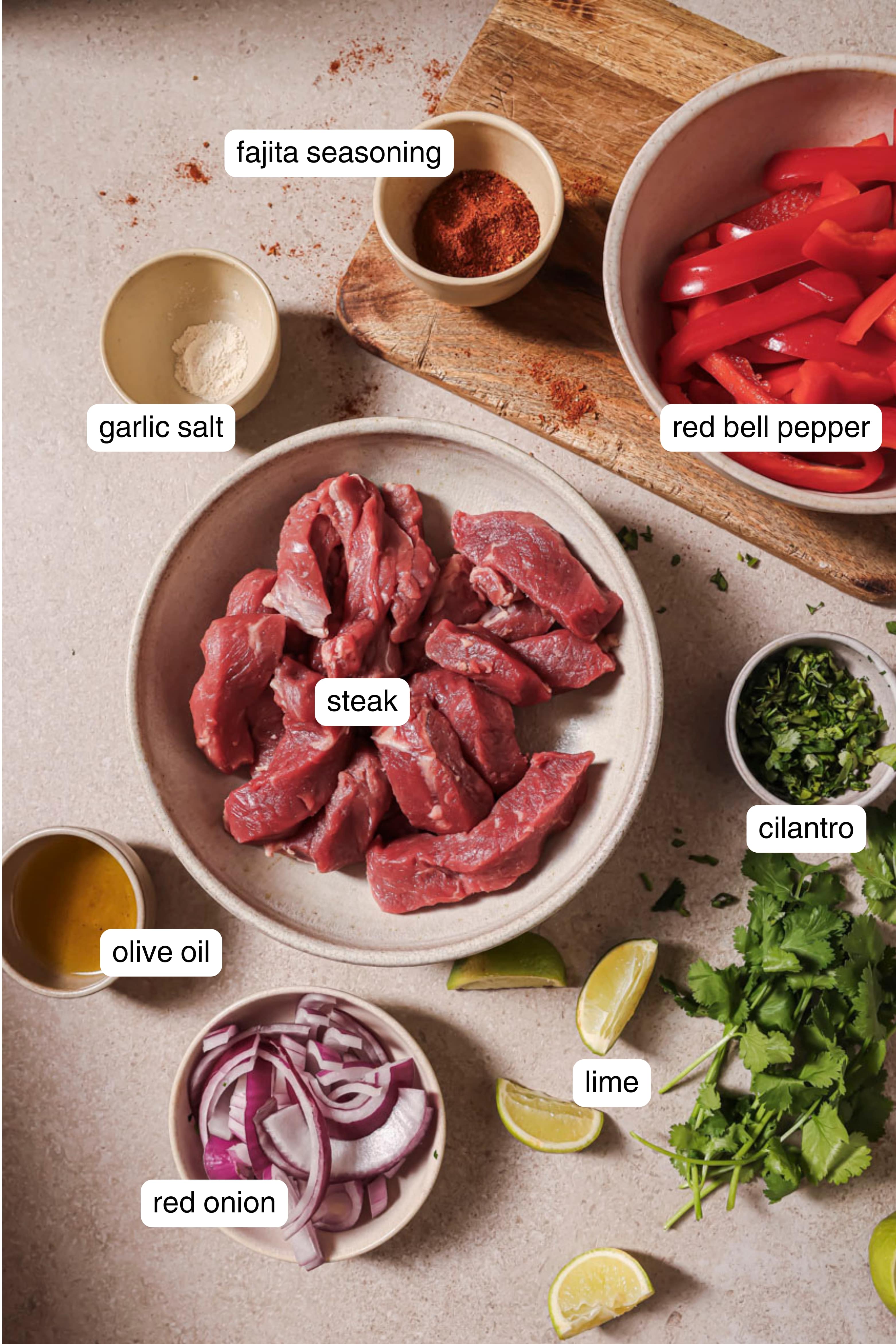 Labeled ingredients for air fryer steak fajitas.