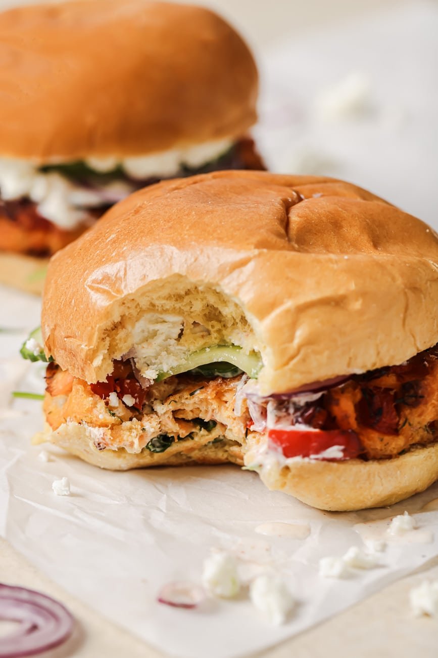Close up of an air fryer salmon burger with a bite taken out of it.