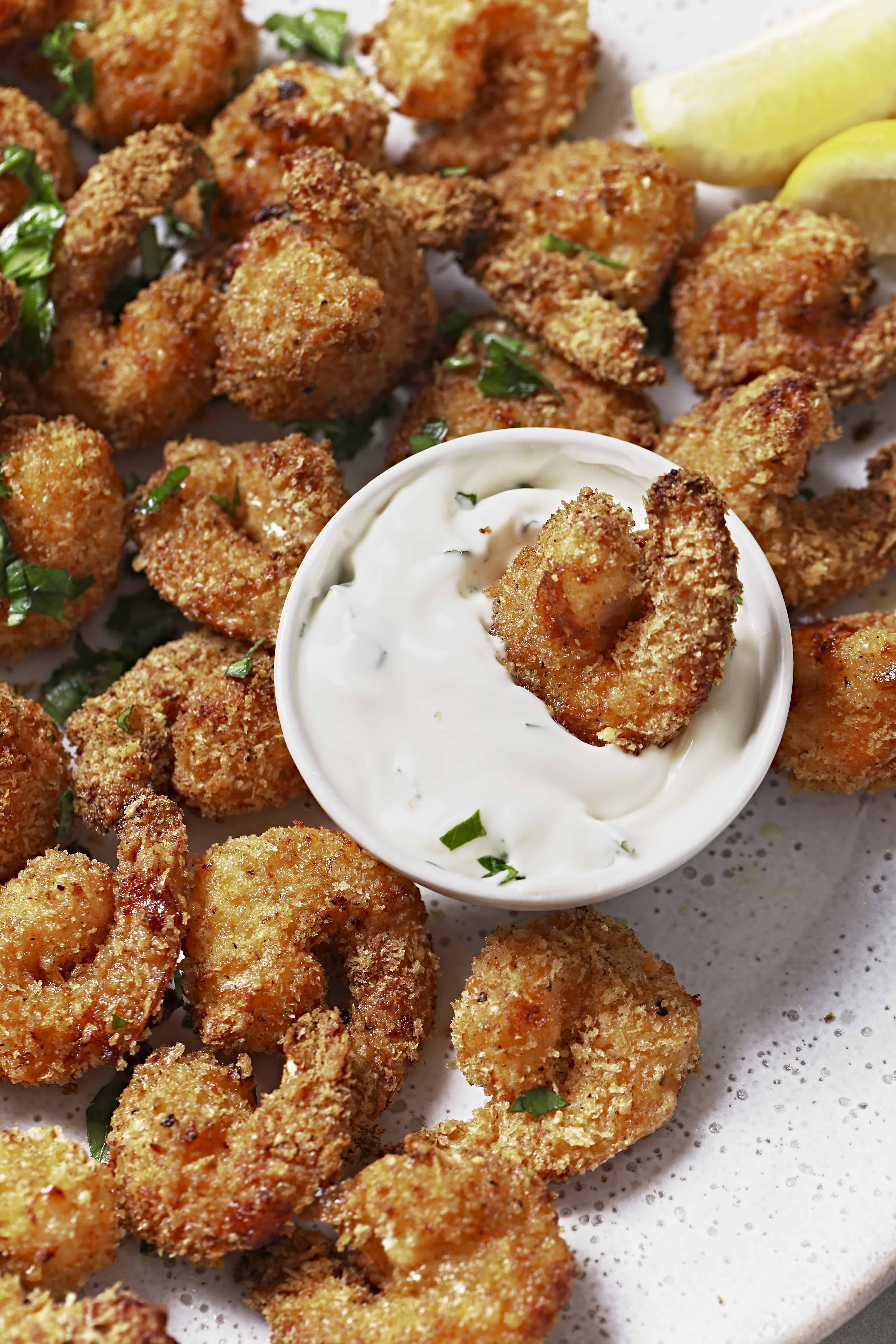 Overhead shot of a platter of popcorn shrimp with a dish of dipping sauce.
