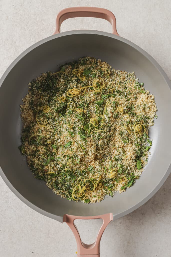 Adding herbs and lemon zest to panko breadcrumbs.
