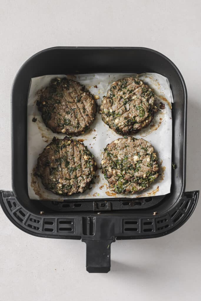 Cooked turkey burgers in an air fryer.