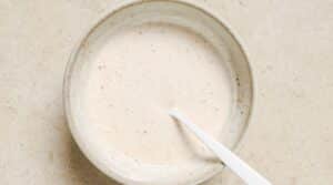 Salmon burger sauce in a white bowl with a white spoon.