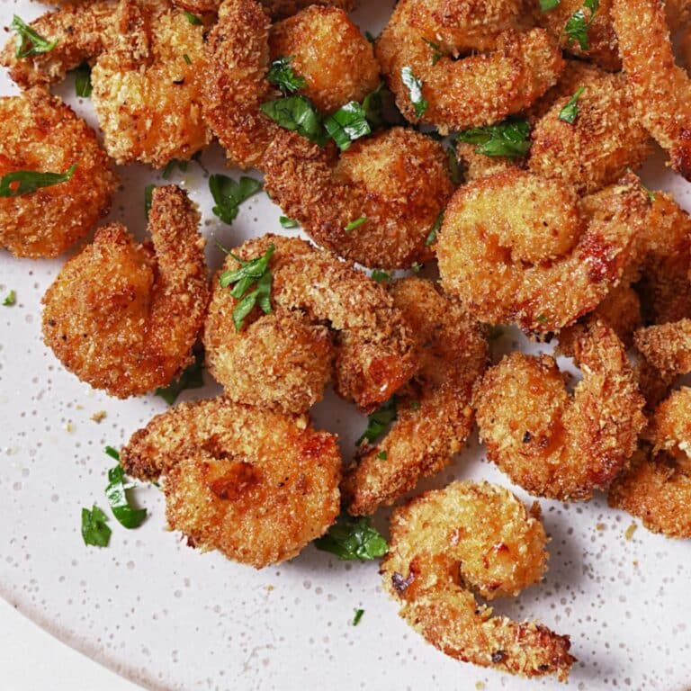 Top down view of crispy popcorn shrimp on a platter.