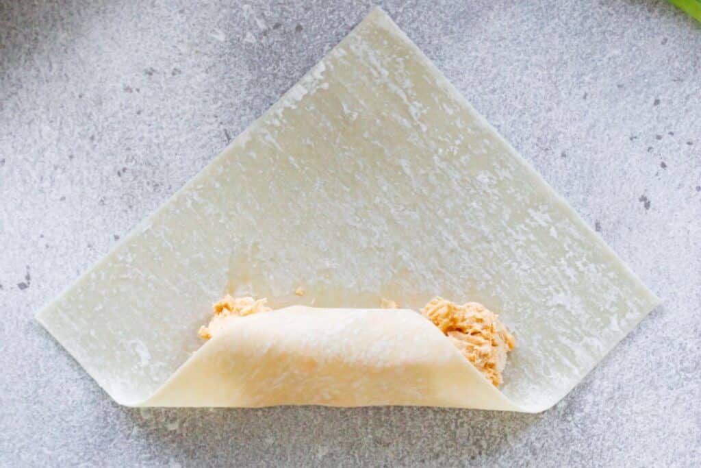 Wrapping a buffalo chicken egg roll.