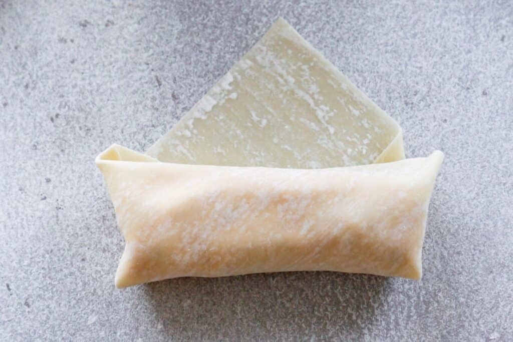 Rolling up a buffalo chicken egg roll.