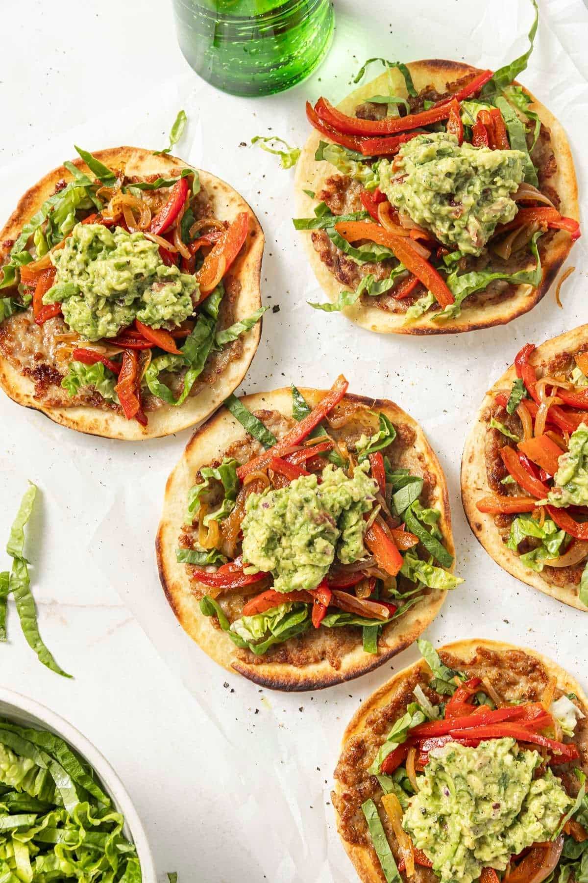Several tiktok taco trend smashburger tacos on a parchment paper covered surface.