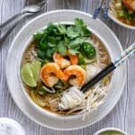 Overhead shot of shrimp pho in a bowl with chopsticks.