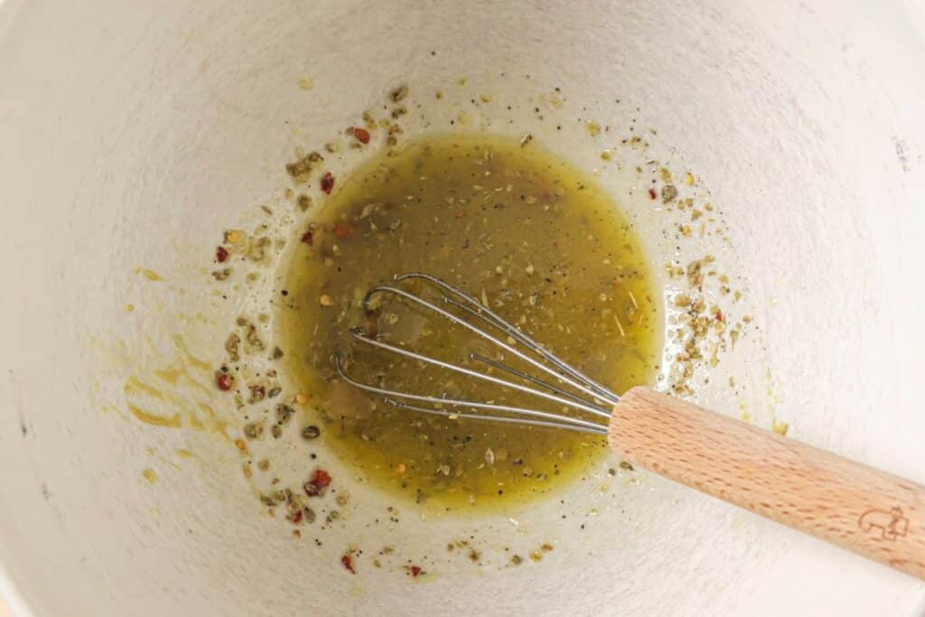 Whisking dressing in a bowl.